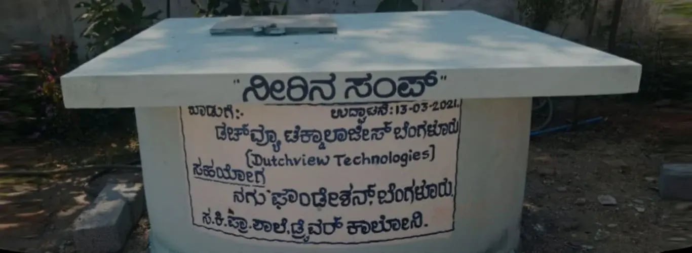 Watertank bij een openbare basisschool in Karnataka met een opschrift in het Kannada dat Dutchview Technologies en NAGU Foundation noemt